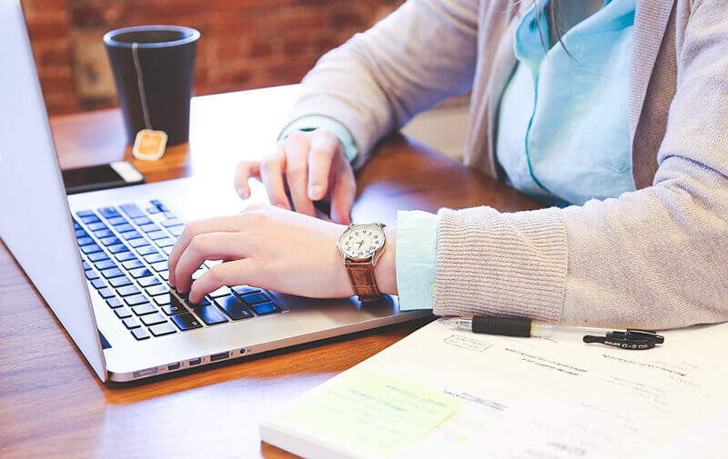 Writing Skills are essential for professionals. Young person writing on a laptop